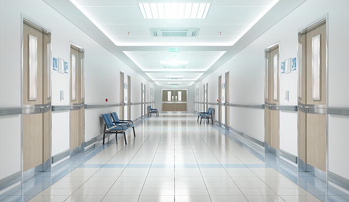 Clean hospital corridor with wooden doors and seating area