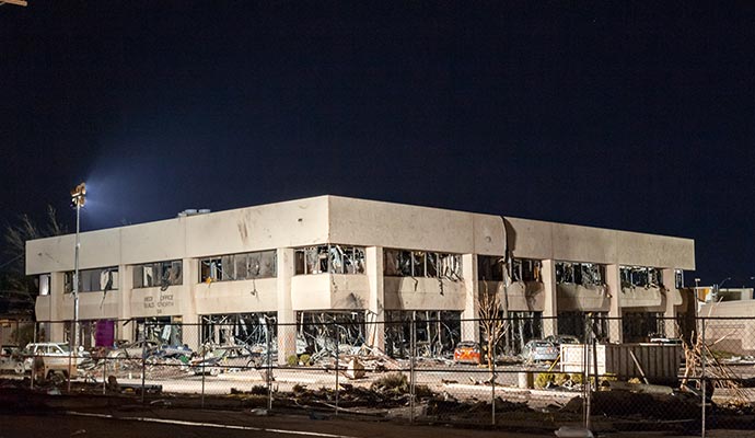 Healthcare facility with shattered windows and structural damage after a severe disaster