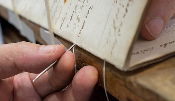 Hand sewing process to repair damaged paper documents