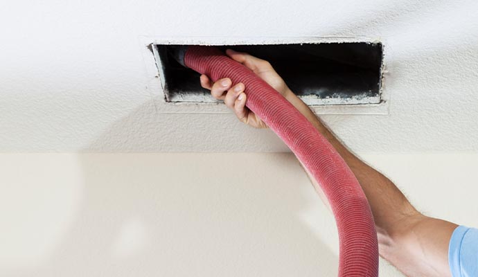 Professional worker cleaning duct
