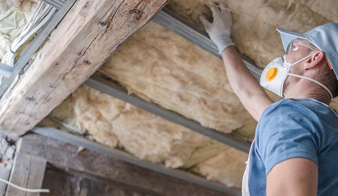 A person is installing attic insulation