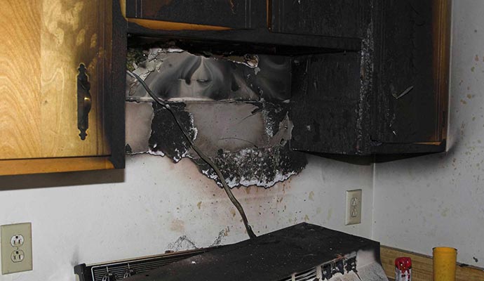 Fire damaged kitchen cabinet with visible burn marks