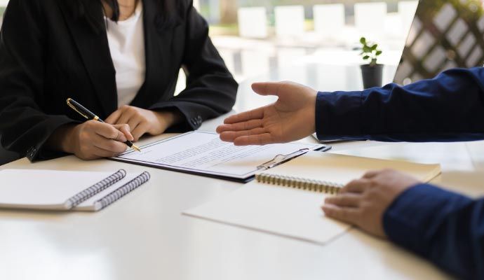 Professional insurance agent helping a client understand policy details before signing documents