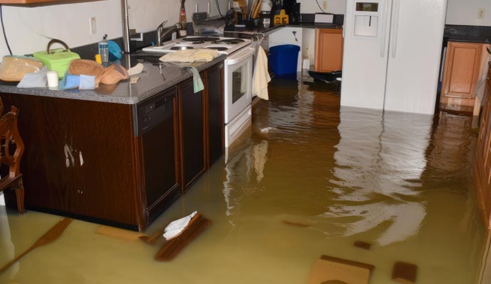 Kitchen interior flooded with water covering the floor and partially submerging furniture