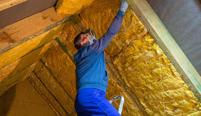 A person is replacing roof attic insulation