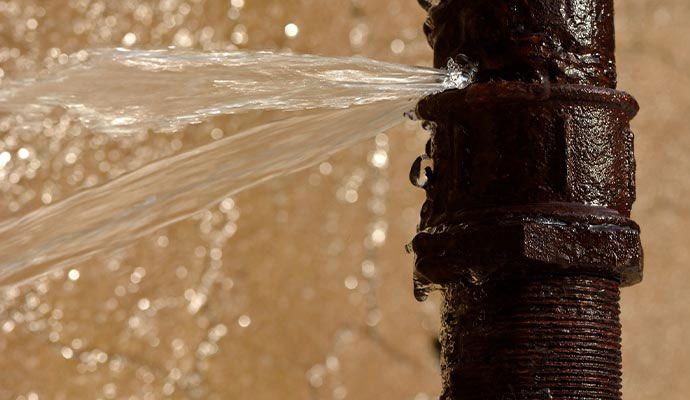 Water spraying out from burst rusted pipe